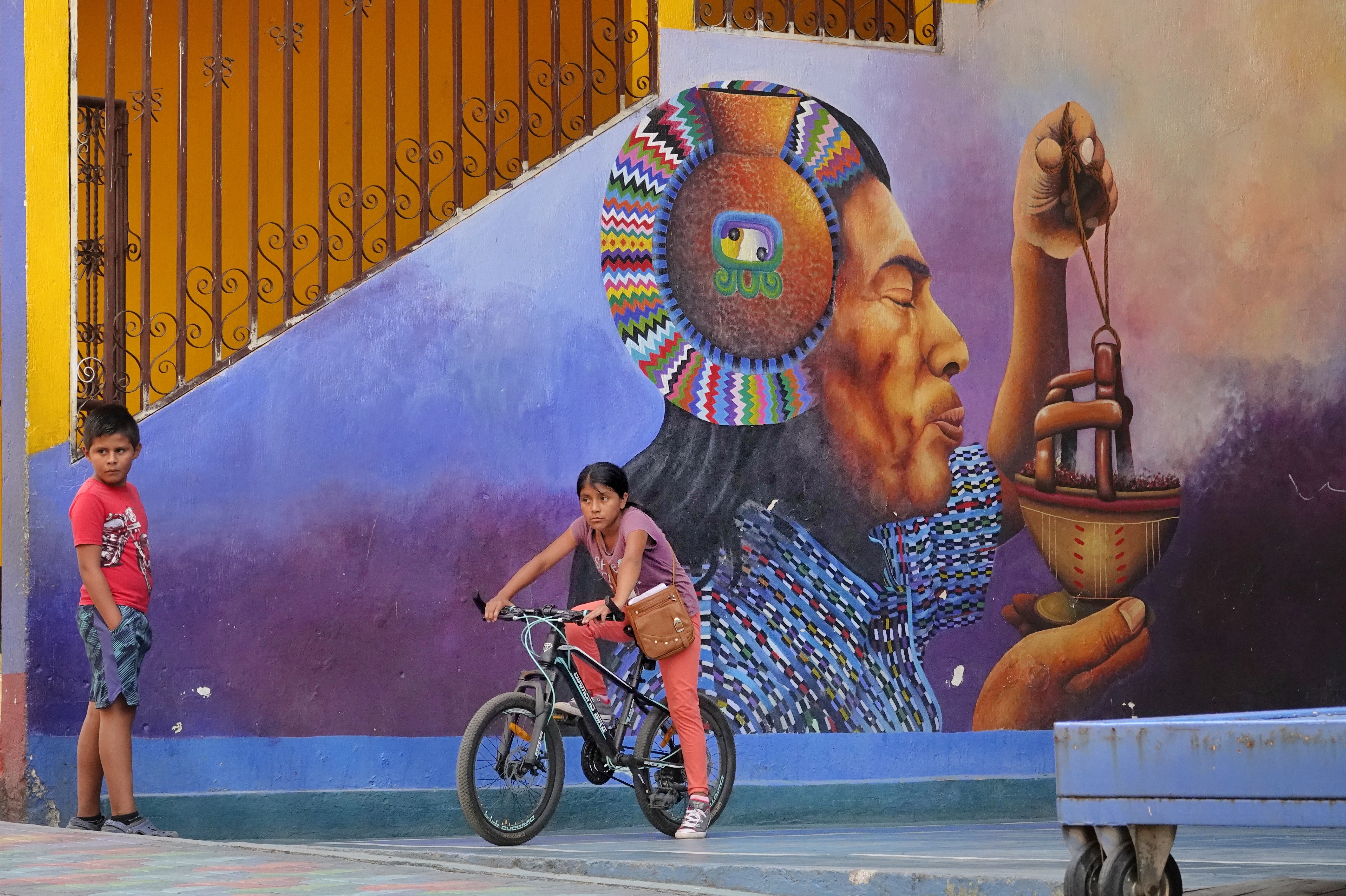 Enfant à vélo devant une fresque murale